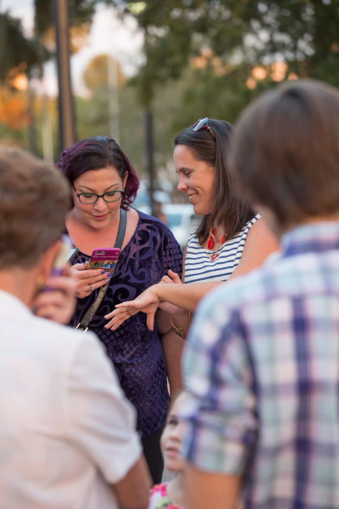 friend taking photo of engagement ring