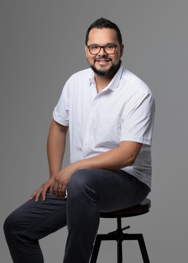 young mad wearing white shirt sitting on a stool