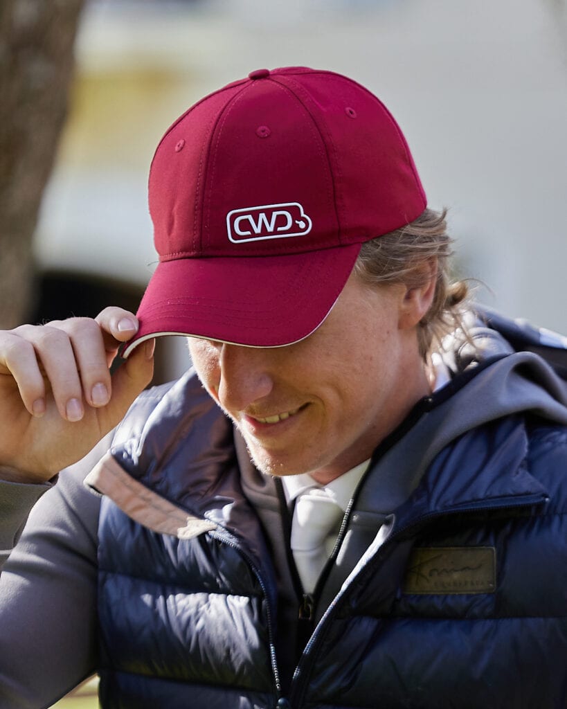 Young man tipping his red ball cap